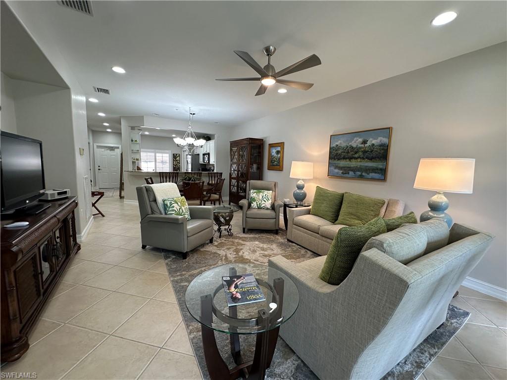 9113 Michael Circle, Unit 7710 Naples, FL 34113 - Photo 7 of 34 a living room with furniture and a flat screen tv