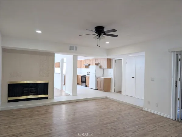 a view of a room with wooden floor and a fireplace