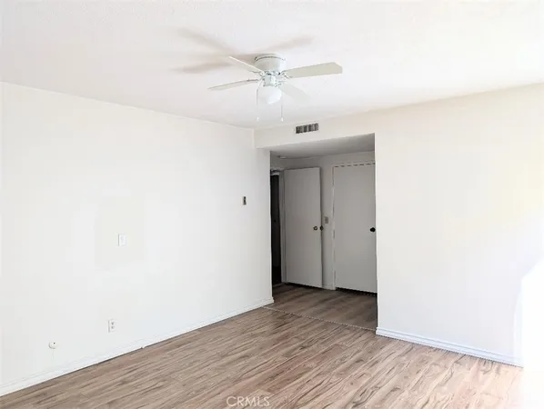 a view of an empty room with wooden floor