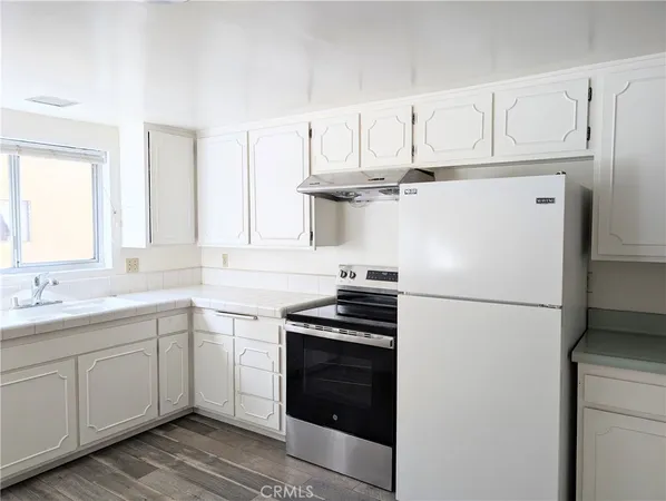 a kitchen with appliances a sink and cabinets