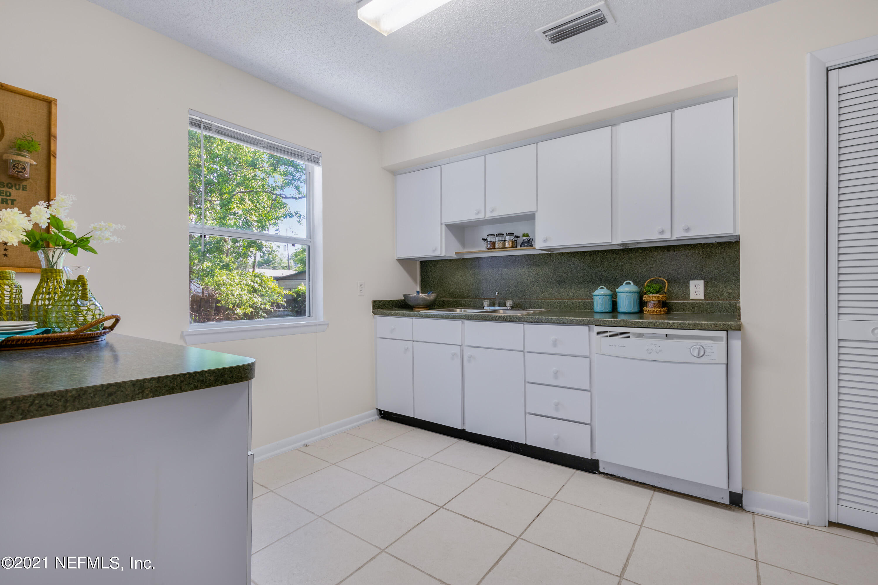 6554 Aires Road Jacksonville, FL 32244 - Photo 12 of 29 a kitchen with stainless steel appliances granite countertop white cabinets a window and a sink