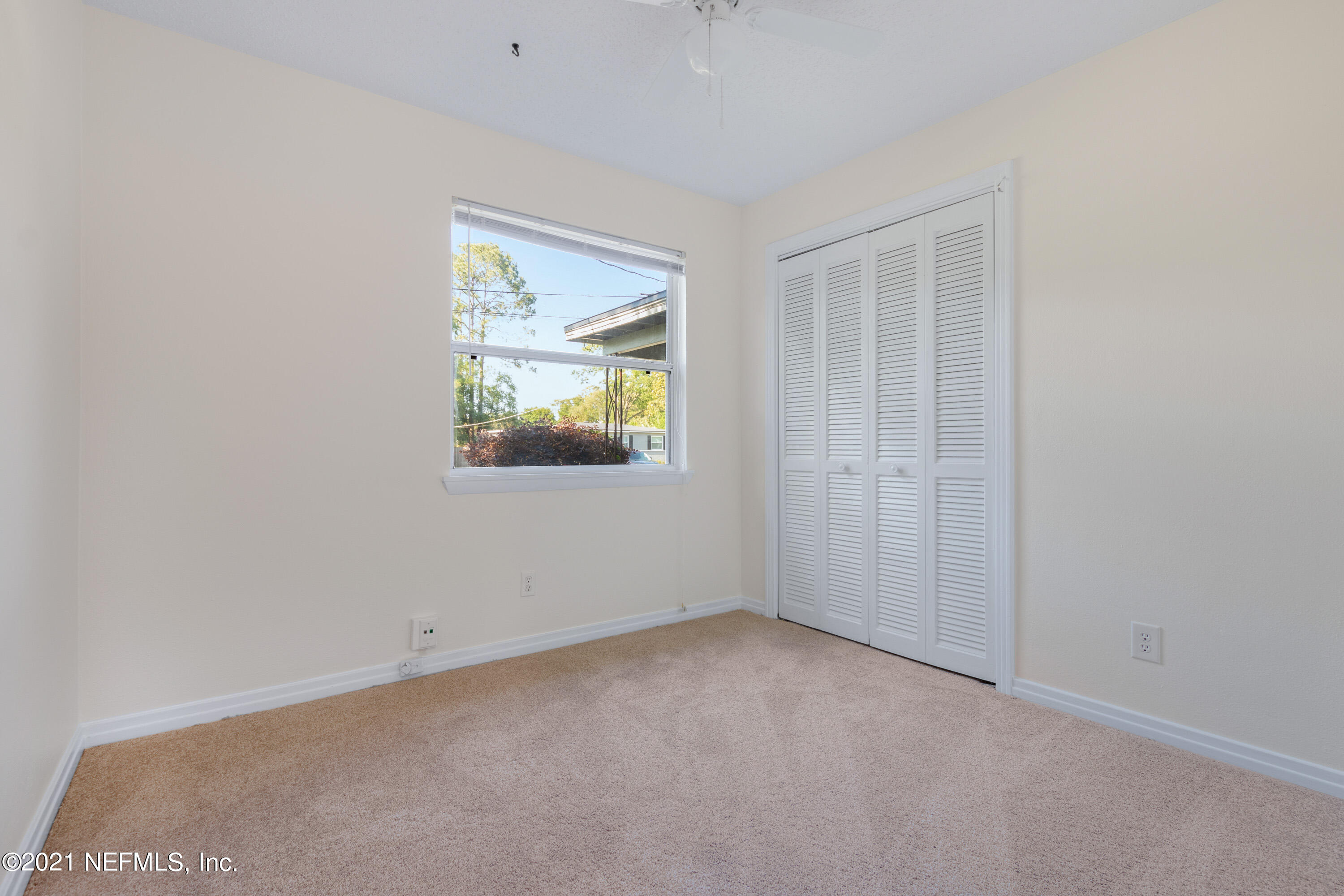 6554 Aires Road Jacksonville, FL 32244 - Photo 21 of 29 an empty room with a window and wooden floor