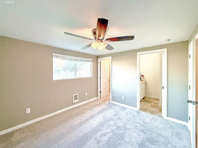 a view of a room with a ceiling fan and window