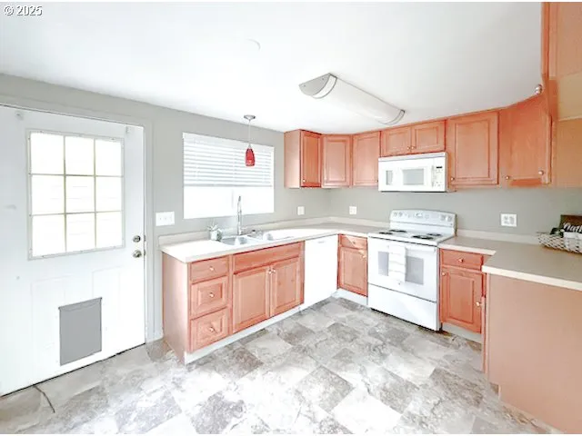a large kitchen with granite countertop a sink window and cabinets
