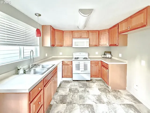 a large kitchen with a stove a sink dishwasher and a refrigerator