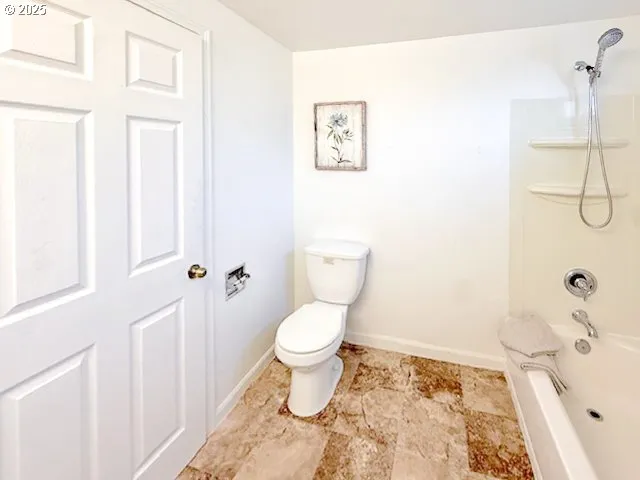 a bathroom with a toilet and a shower