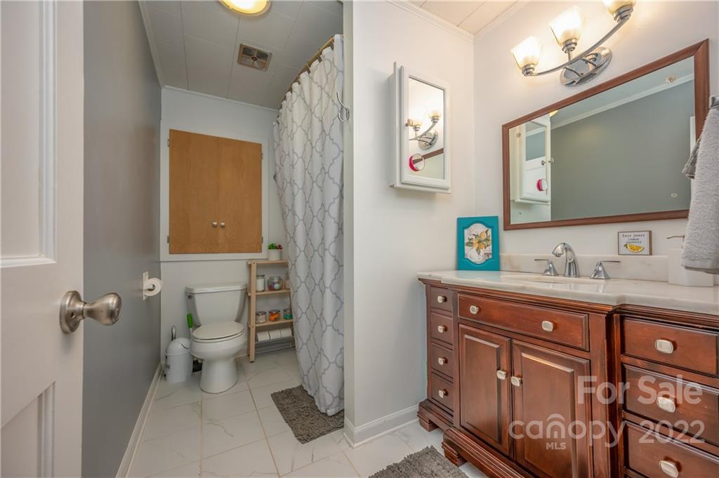 244 South Main Street Rutherfordton, NC 28139 - Photo 8 of 30 a bathroom with a granite countertop toilet sink and mirror
