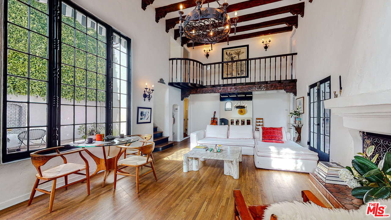 a living room with furniture stairs and a large window