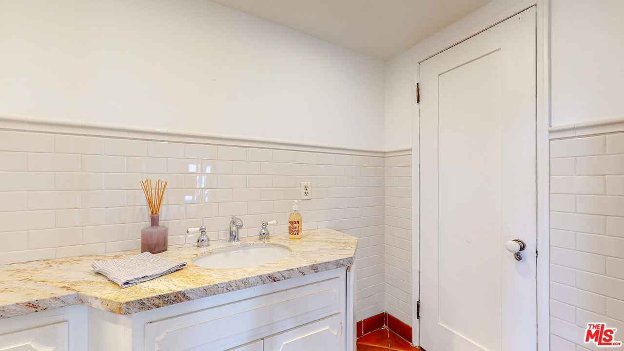 6854 Iris Circle Los Angeles, CA 90068 - Photo 13 of 35 a bathroom with a granite countertop sink and a mirror