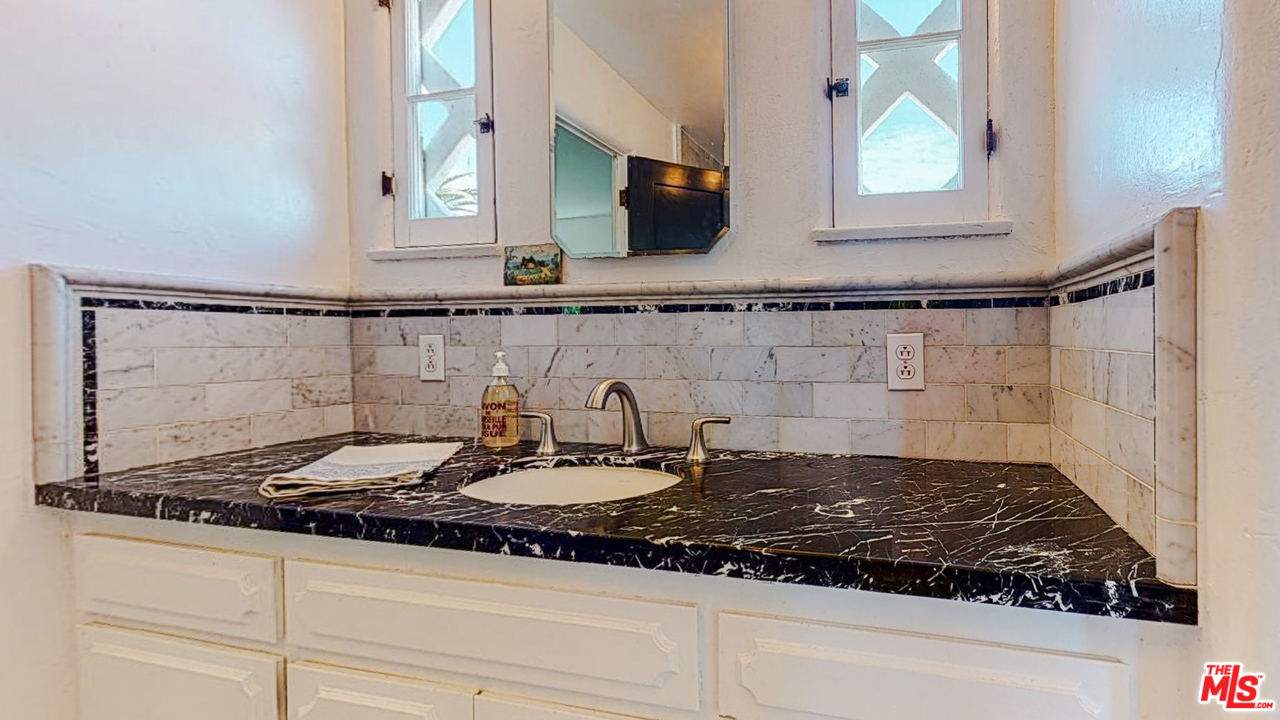 6854 Iris Circle Los Angeles, CA 90068 - Photo 21 of 35 a bathroom with a granite countertop sink and a mirror