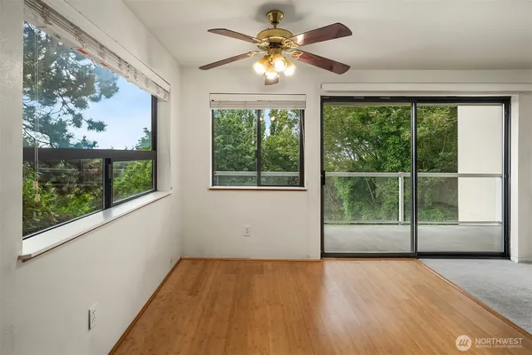 a view of an empty room with wooden floor and a window