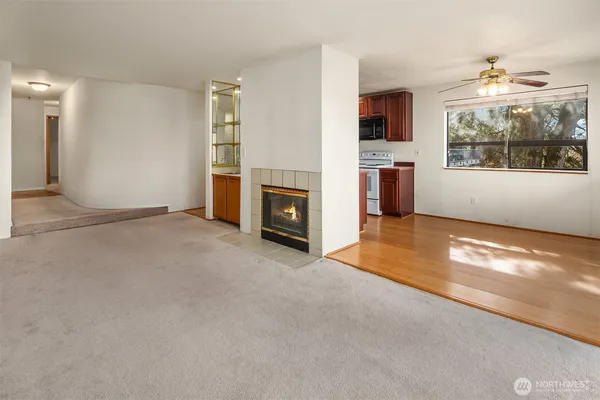 an empty room with windows and fireplace