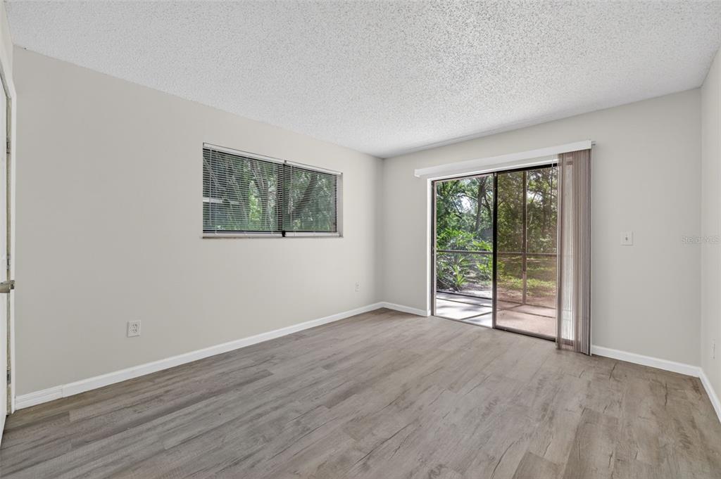 11715 Raintree Village Boulevard, Unit A Temple Terrace, FL 33617 - Photo 12 of 30 a view of an empty room with wooden floor and a window