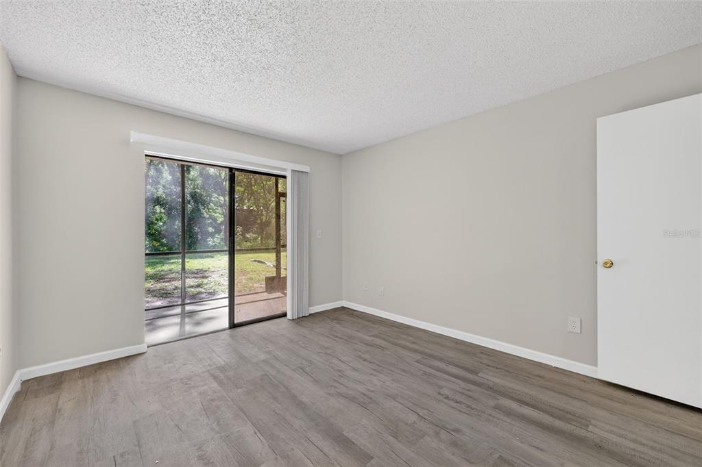 11715 Raintree Village Boulevard, Unit A Temple Terrace, FL 33617 - Photo 13 of 30 a view of an empty room with wooden floor and a window