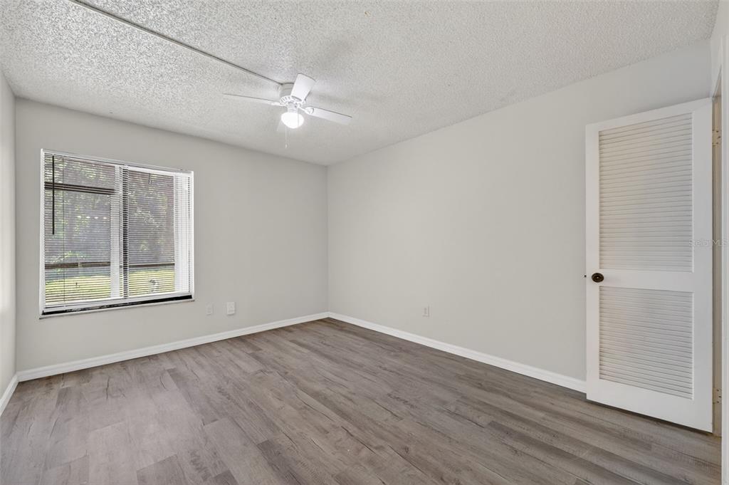 11715 Raintree Village Boulevard, Unit A Temple Terrace, FL 33617 - Photo 16 of 30 a view of an empty room with wooden floor and a window