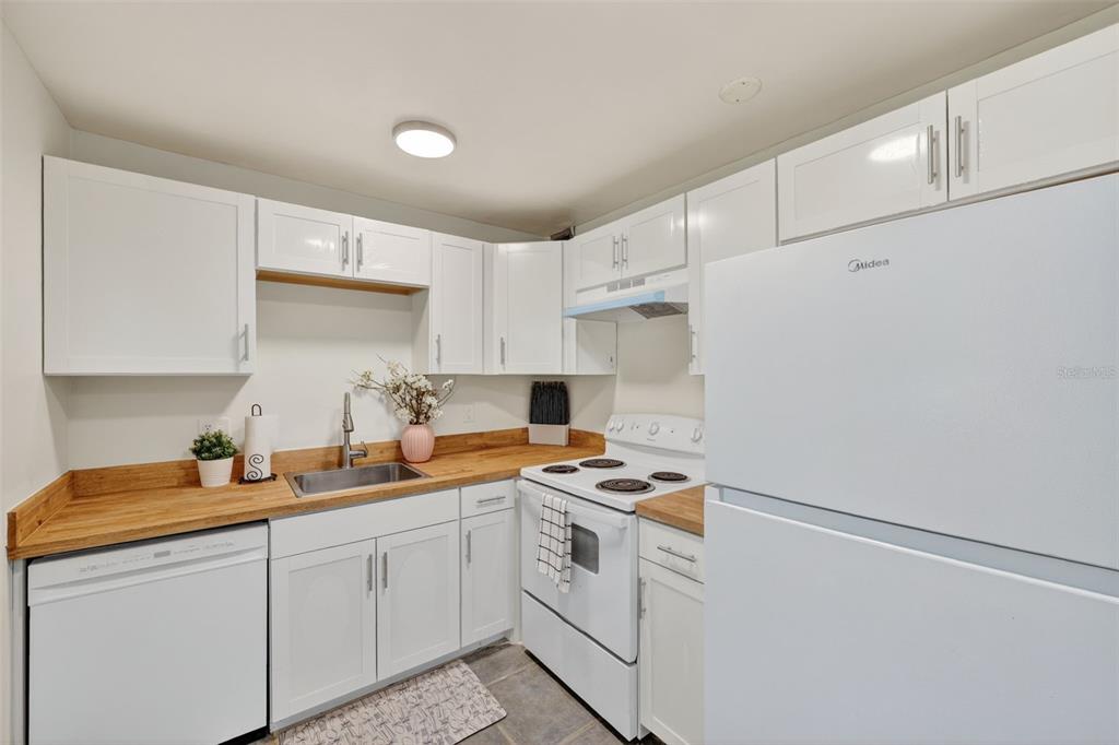 11715 Raintree Village Boulevard, Unit A Temple Terrace, FL 33617 - Photo 2 of 30 a kitchen with cabinets appliances a sink and a counter top space