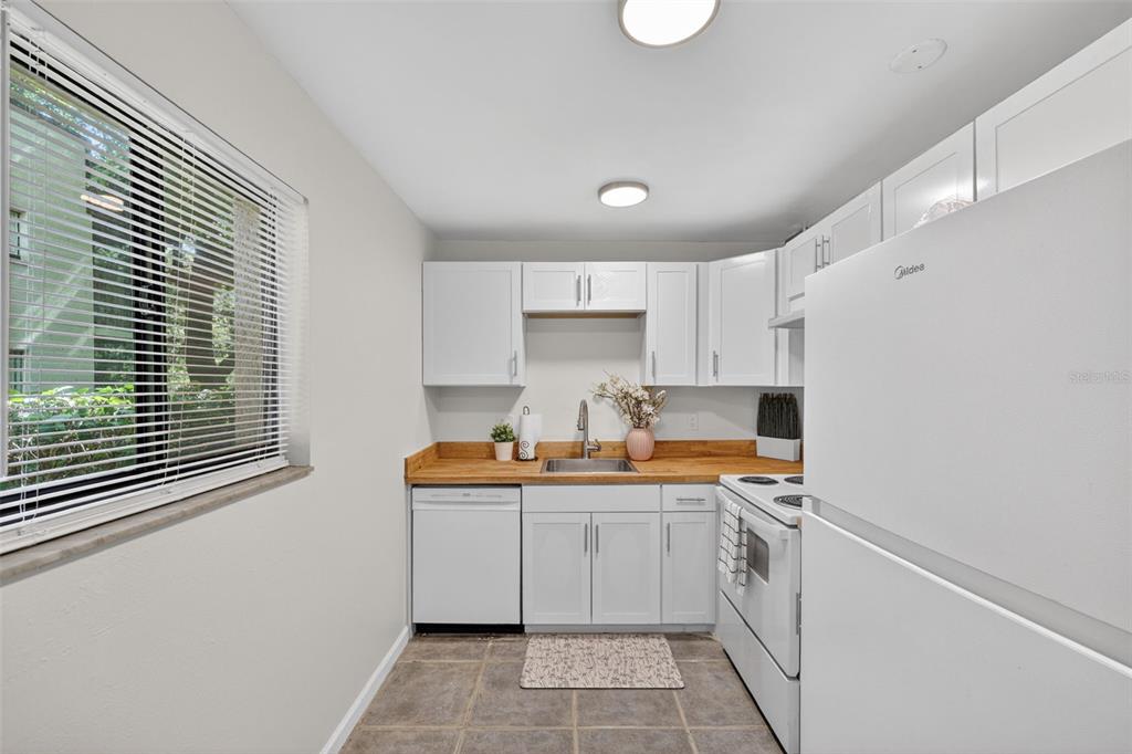 11715 Raintree Village Boulevard, Unit A Temple Terrace, FL 33617 - Photo 4 of 30 a kitchen with a sink stove and cabinets