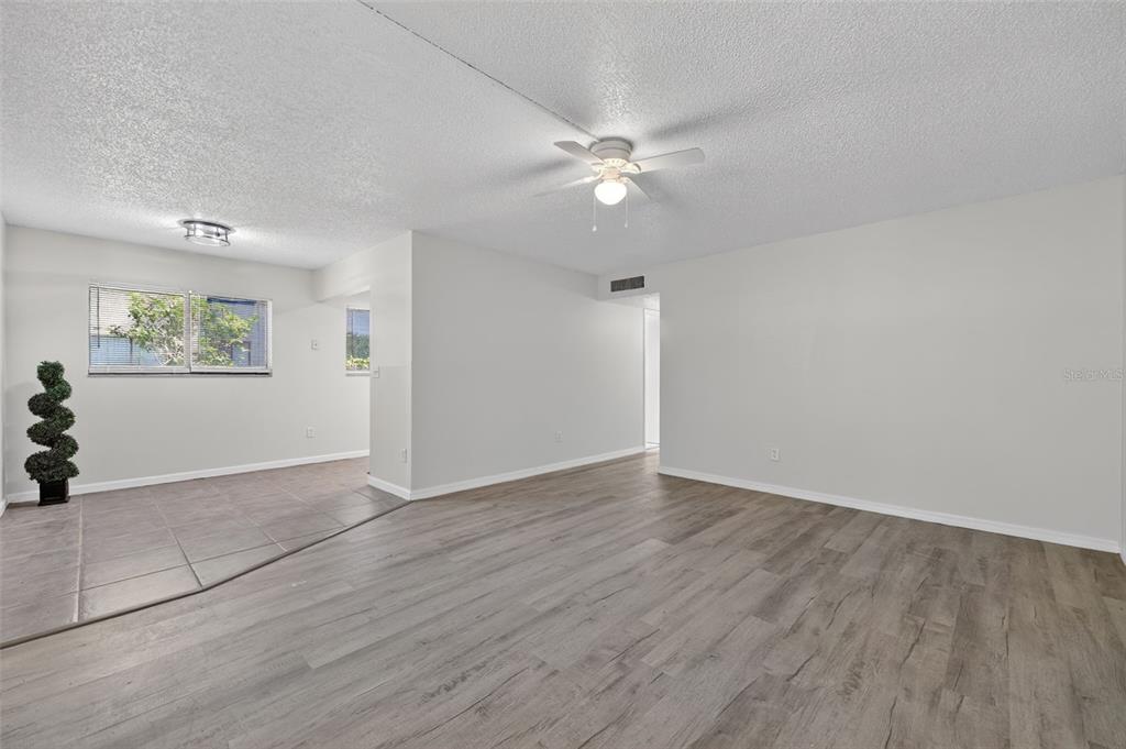 11715 Raintree Village Boulevard, Unit A Temple Terrace, FL 33617 - Photo 6 of 30 an empty room with wooden floor fan and windows