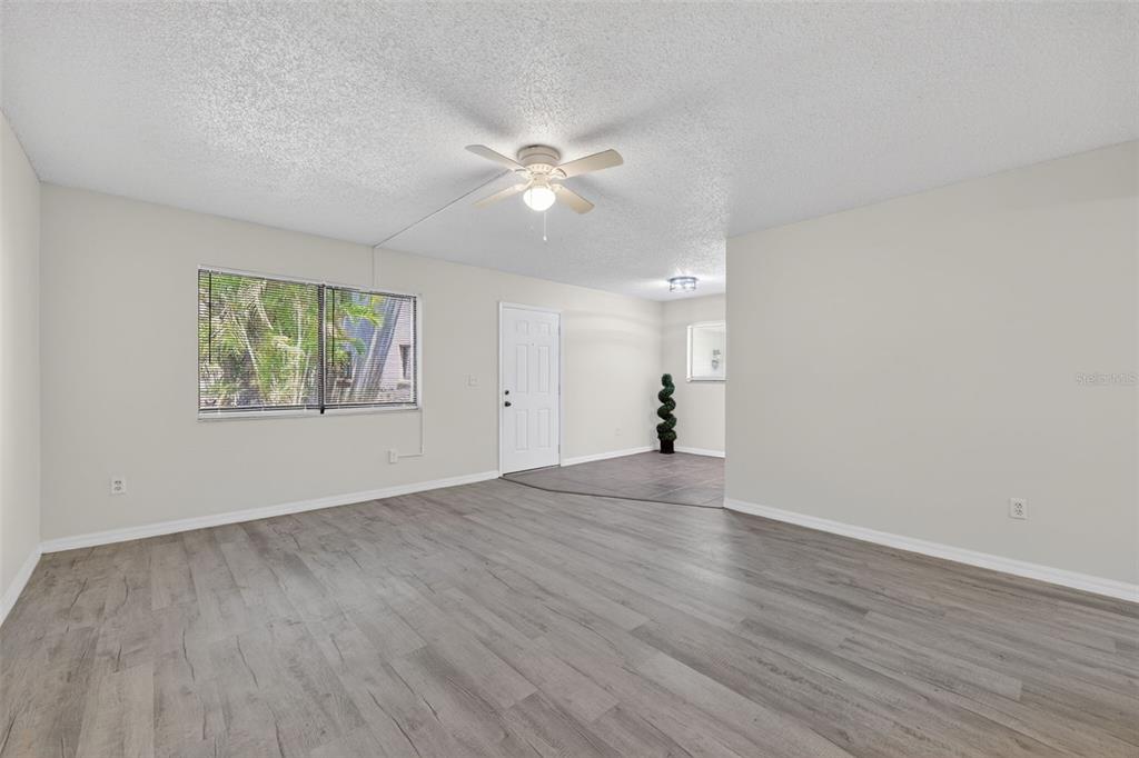 11715 Raintree Village Boulevard, Unit A Temple Terrace, FL 33617 - Photo 7 of 30 an empty room with wooden floor window and ceiling fan