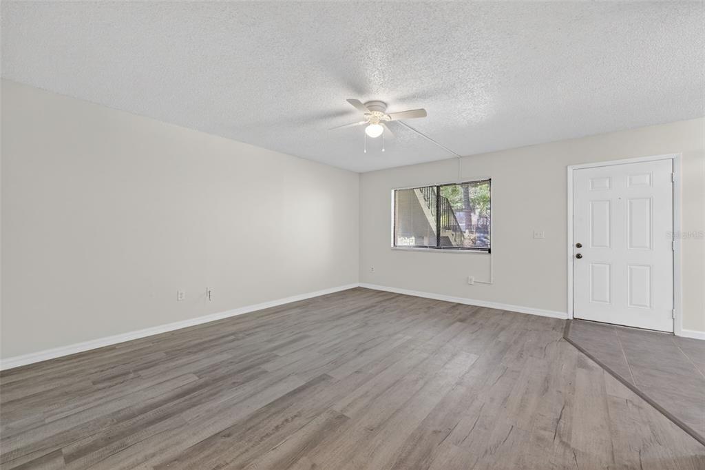 11715 Raintree Village Boulevard, Unit A Temple Terrace, FL 33617 - Photo 8 of 30 an empty room with wooden floor window and ceiling fan
