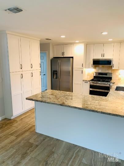 920 Linwood Street Vacaville, CA 95688 - Photo 12 of 38 a kitchen with stainless steel appliances granite countertop a refrigerator a stove and a sink with wooden floor