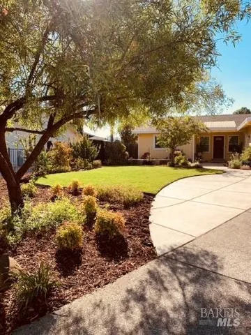 a view of a yard with yellow house