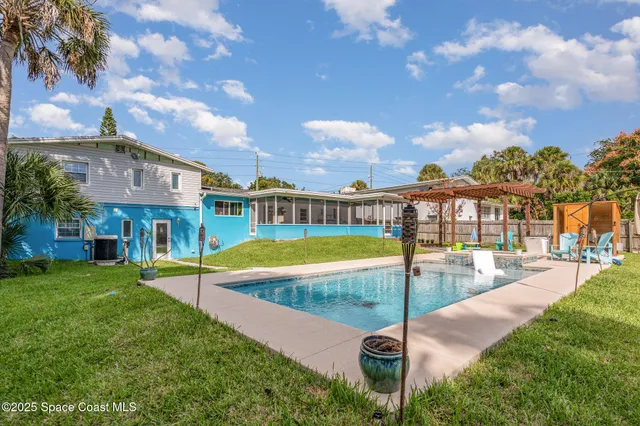 a view of a house with swimming pool and sitting area