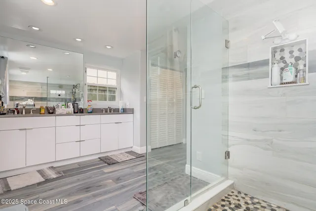 a bathroom with a shower sink and mirror