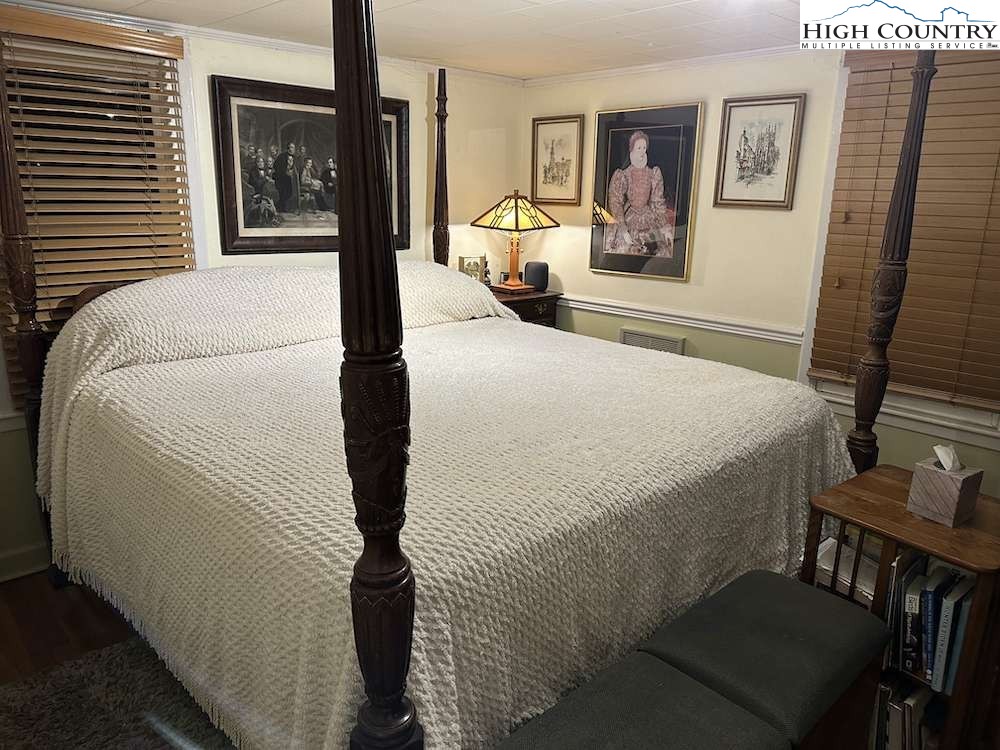 333 Mt Zion Road Deep Gap, NC 28618 - Photo 21 of 25 a bedroom with a bed and dresser with wooden floor
