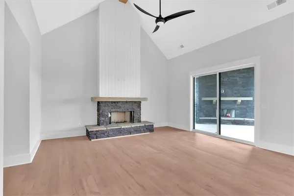 a view of empty room with wooden floor and fireplace