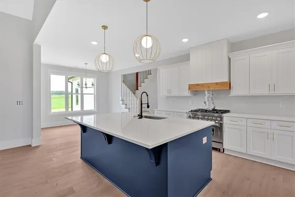 a kitchen with a sink a stove a dining table and chairs