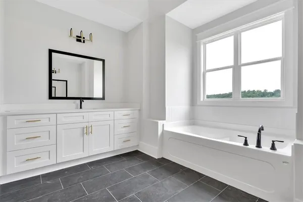a bathroom with a bathtub sink and mirror