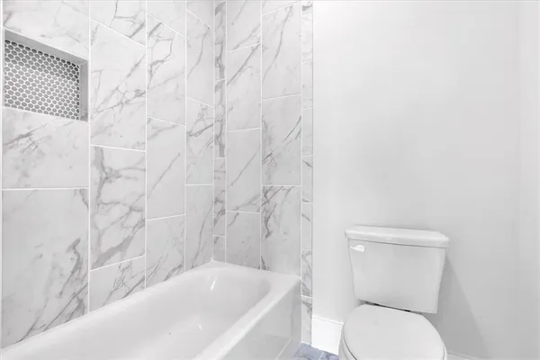 a bathroom with a toilet and a bath tub