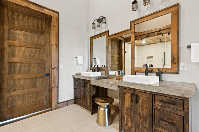 a bathroom with a granite countertop sink a mirror and shower