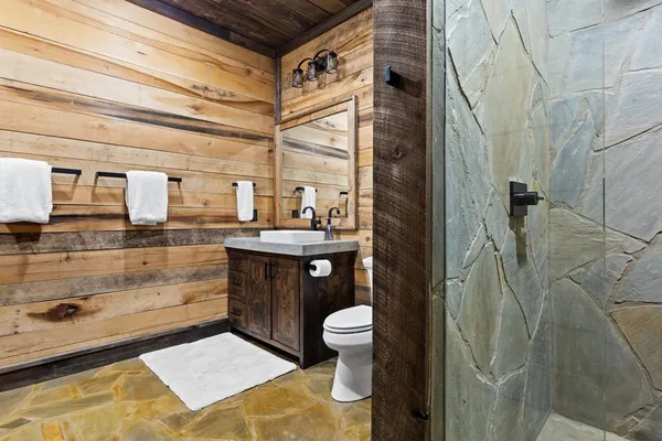 a bathroom with a sink a toilet and shower