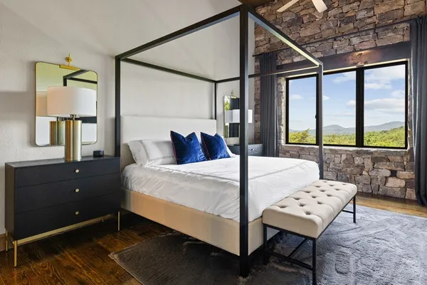 a bedroom with a bed mirror and window