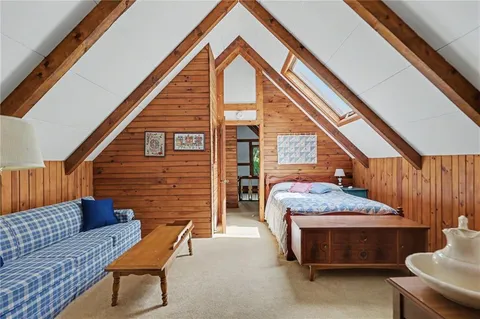a bedroom with a bed a dresser next to a window