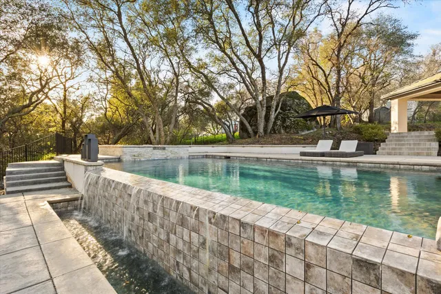 a view of swimming pool with outdoor seating and lake view