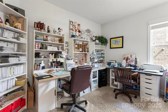a view of a workspace with furniture and a bookshelf