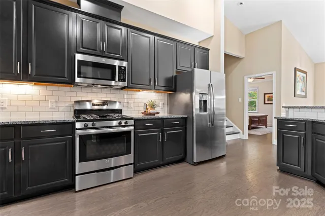 a kitchen with stainless steel appliances granite countertop a stove microwave and refrigerator