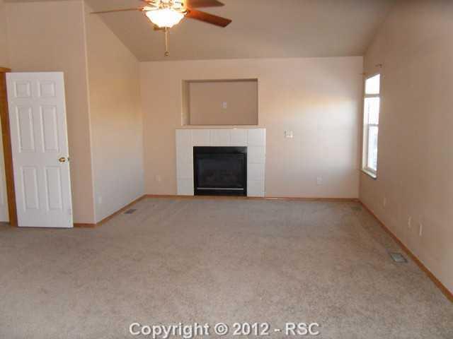 12336 Snaffle Bit Road Peyton, CO 80831 - Photo 5 of 8 Luxurious master suite with high ceilings and a dedicated gas fireplace. Enjoy the convenience of an attached bath and walk-in closet.