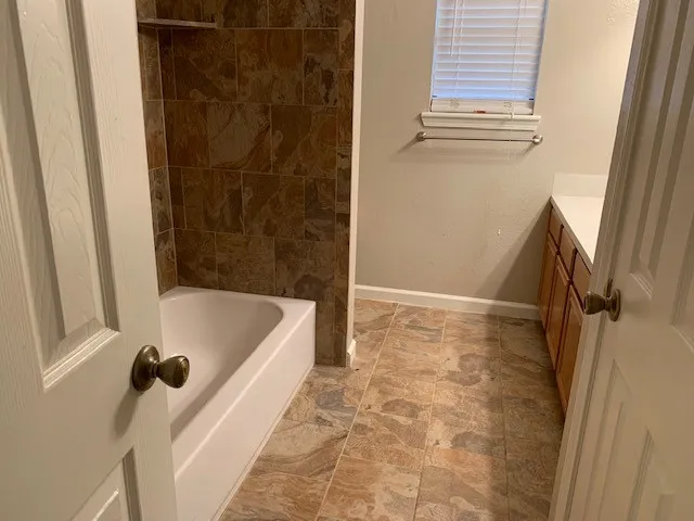 a bathroom with a tub a window and a shower