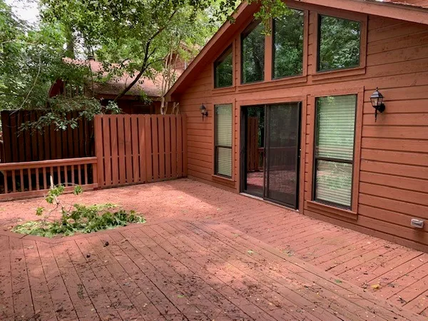 a view of backyard with deck and wooden fence