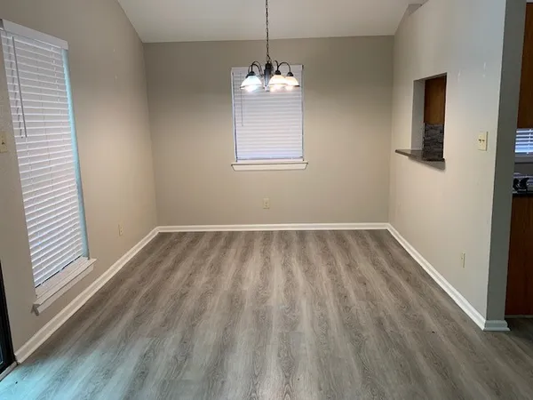 a view of a room with wooden floor and windows