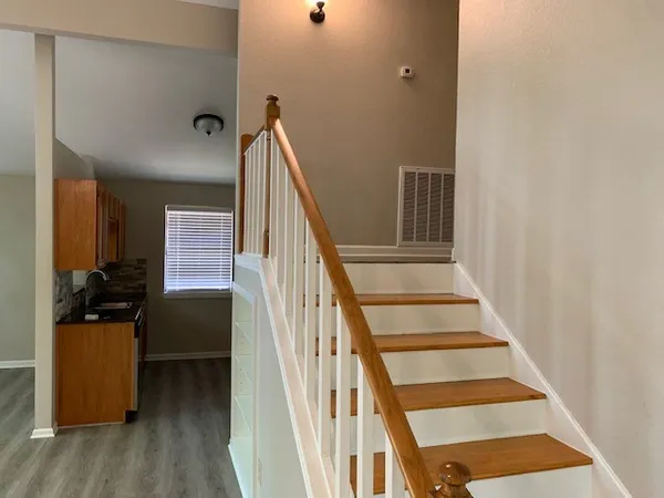 a view of a hallway with wooden floor and staircase