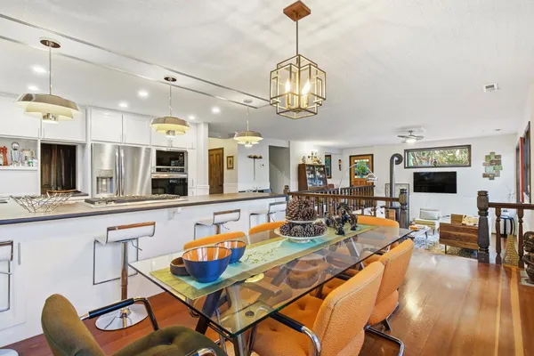 a kitchen with stainless steel appliances kitchen island a table and chairs in it