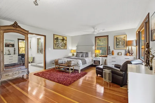 a bedroom with a bed and wooden floor