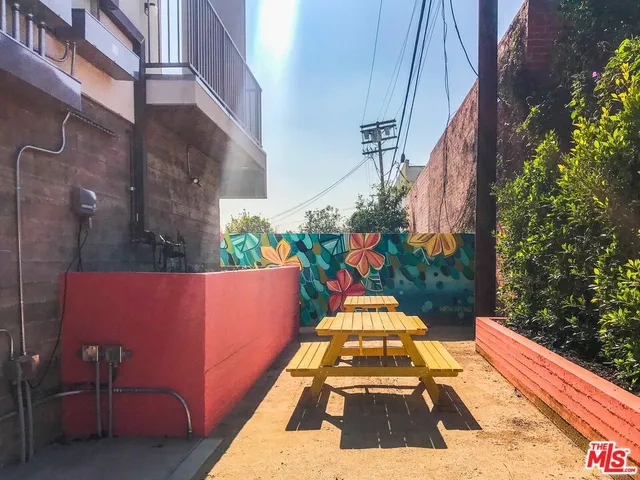 a kitchen with stainless steel appliances kitchen island granite countertop a refrigerator and a wooden cabinets