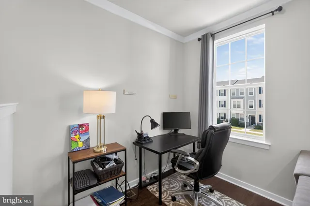 a view of a workspace with furniture and a window