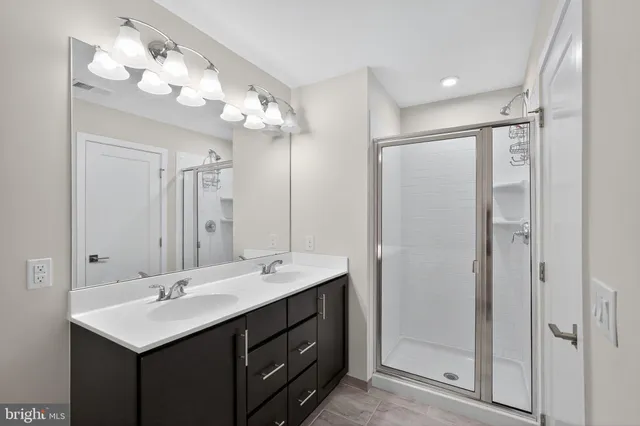 a bathroom with a sink vanity mirror and shower